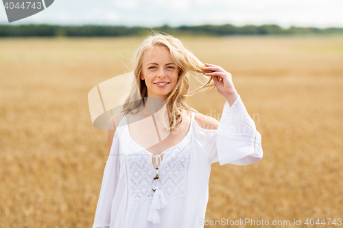 Image of smiling young woman in white dress on cereal field