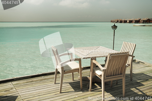 Image of outdoor restaurant terrace with furniture over sea