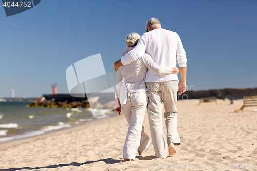 Image of happy senior couple hugging on summer beach