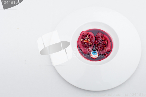 Image of sliced stuffed pear in wine