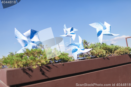 Image of Toy windmills in a flowerpot with flowers