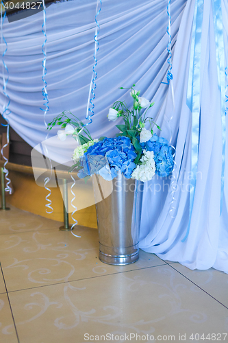 Image of Bouquet of white and blue flower in metal vase