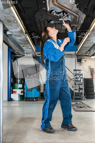 Image of Female Mechanic Repairing Car On Hydraulic Lift