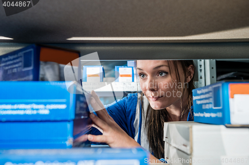 Image of Mechanic Picking Up Boxes From Storage Rack At Garage