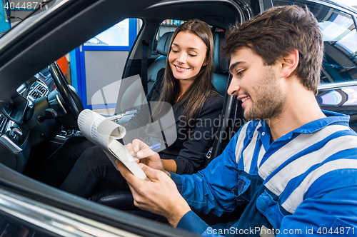 Image of Car Mechanic With Customer Going Through Maintenance Checklist