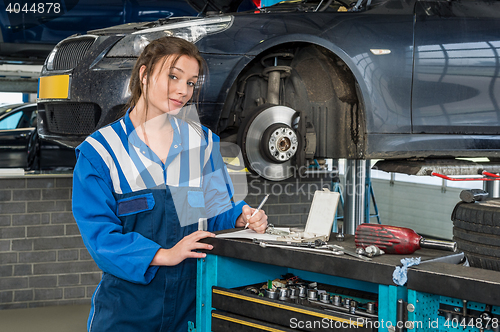 Image of Confident Female Mechanic Writing Notes In Garage