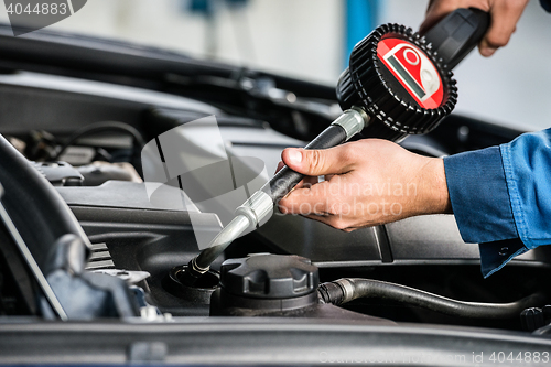 Image of Mechanic Hands Filling Oil Into Car\'s Engine At Garage