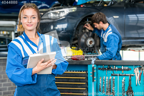 Image of Confident Female Mechanic With Maintenance Checklist At Garage