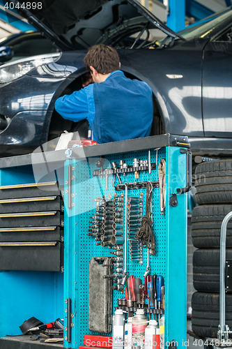 Image of Tool Cart With Male Mechanic Repairing Car