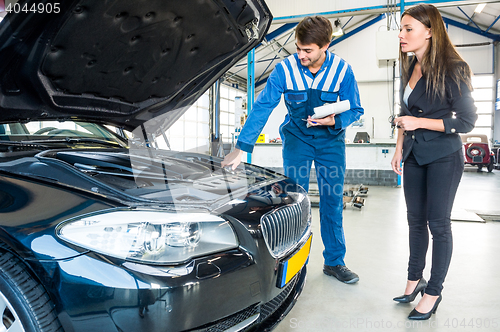 Image of Mechanic Talking To Female Customer About Car Engine