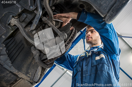 Image of Mechanic Repairing Suspension System Of Car In Garage