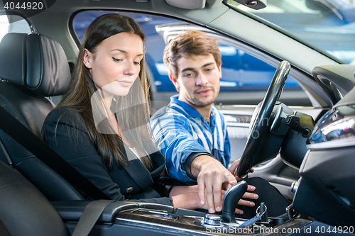 Image of Woman Looking At Mechanic Checking Gearshift Of Car