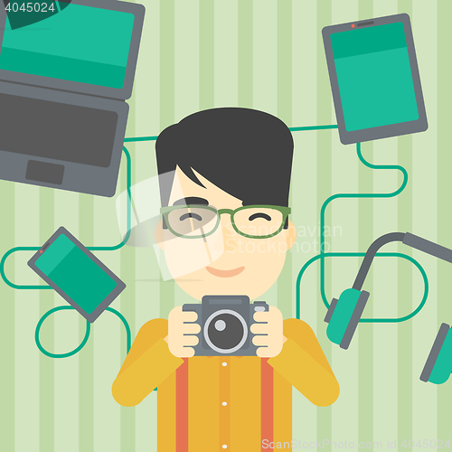 Image of Young man surrounded with his gadgets.