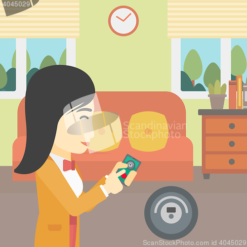 Image of Woman controlling vacuum cleaner with smartphone.