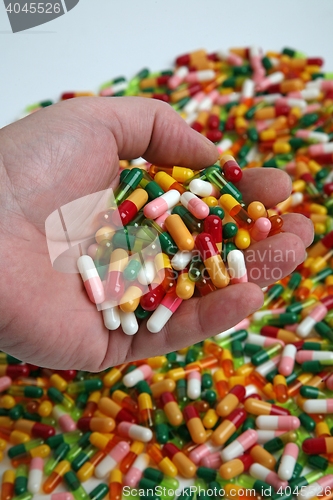 Image of Hands full of medication pill capsules