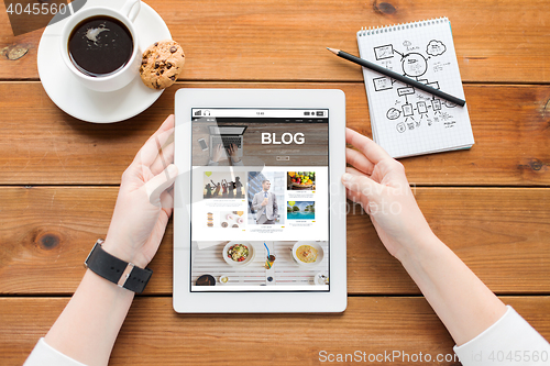 Image of close up of woman with tablet pc on wooden table