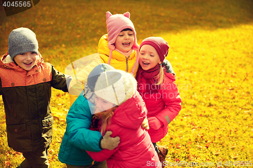 Image of group of happy children hugging in autumn park