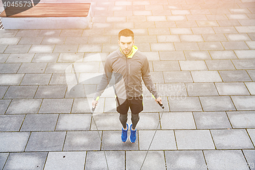 Image of man exercising with jump-rope outdoors