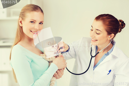 Image of happy woman with cat and doctor at vet clinic