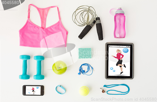 Image of close up of tablet pc, cellphone and sports stuff