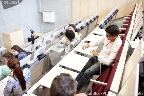 Image of group of students with notebooks in lecture hall