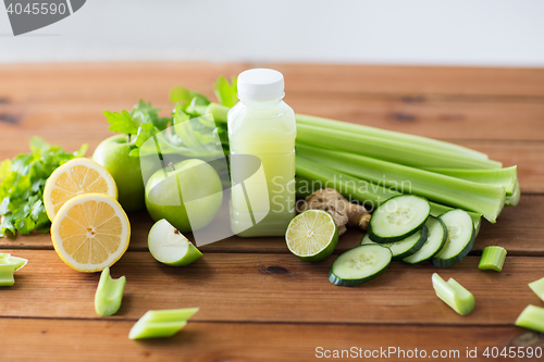 Image of close up of bottle with green juice and vegetables