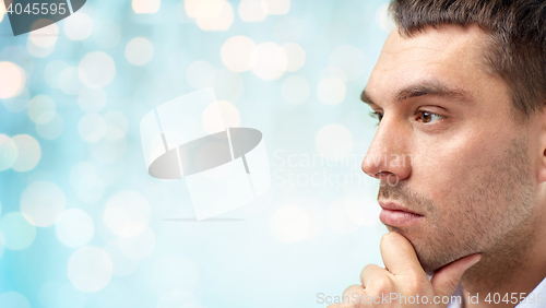 Image of close up of male face over blue lights background