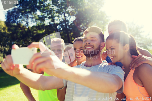 Image of happy friends taking selfie with smartphone