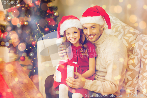 Image of smiling father and daughter holding gift box