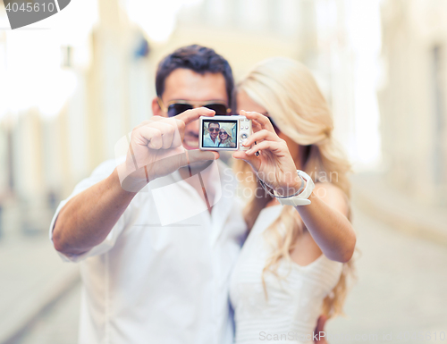 Image of travelling couple taking photo picture with camera