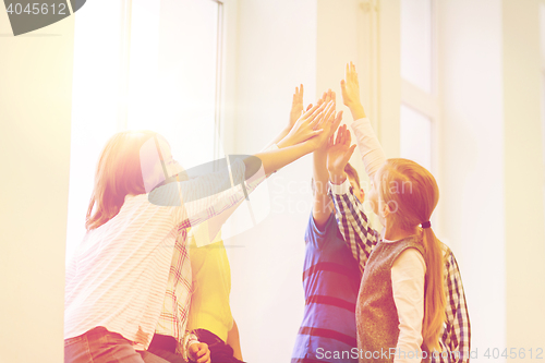 Image of group of school kids making high five gesture