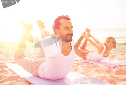 Image of couple making yoga exercises outdoors