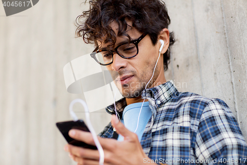 Image of man with earphones and smartphone listening music
