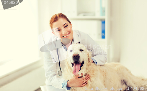 Image of happy doctor with retriever dog at vet clinic