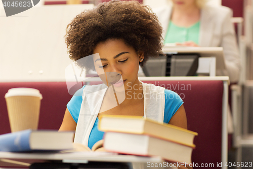 Image of student girl with books and coffee on lecture