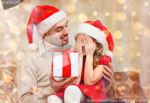 Image of smiling daughter waiting for a present from father