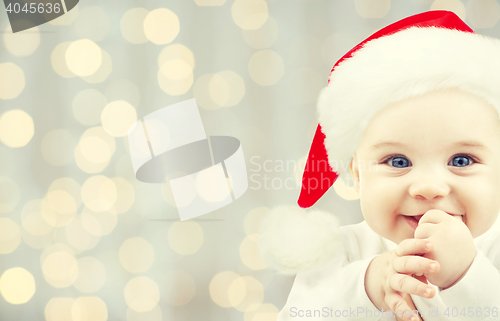 Image of happy baby in santa hat over holidays lights