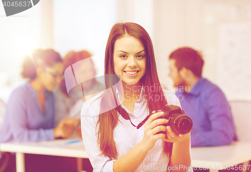 Image of smiling female photographer with photocamera