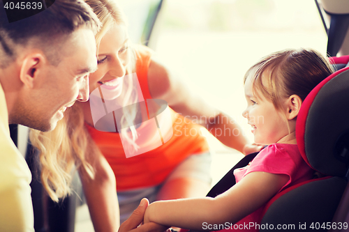 Image of parents talking to little girl in baby car seat