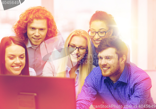 Image of smiling business team looking at computer monitor