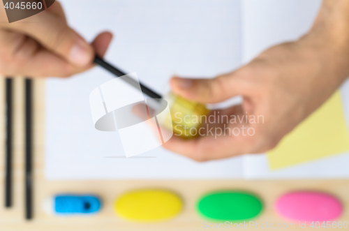 Image of Top view of man\'s hands sharpening pencil