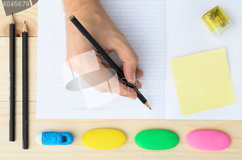 Image of Human hands with pencil and erase rubber