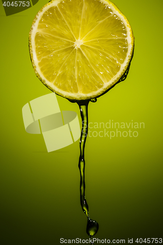 Image of Lime juice pouring down from half of lime
