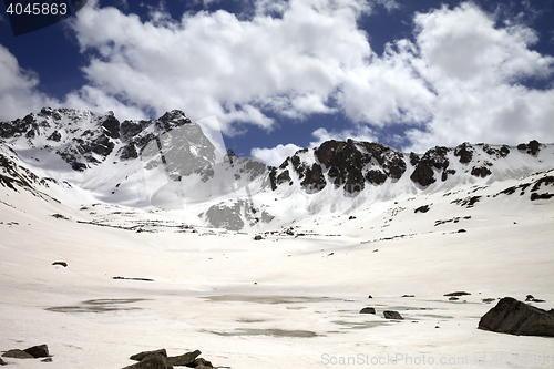 Image of Frozen mountain lake covered with snow at sun day