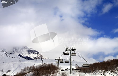 Image of Chair lift on ski resort and snow mountain in clouds