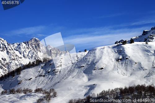 Image of Off-piste slope with track from avalanche on sun day