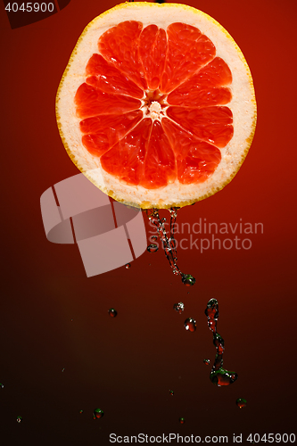 Image of Juicy grapefruit with stream of fresh water.