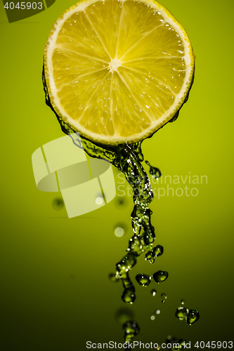 Image of Water splash on lime isolated on green background