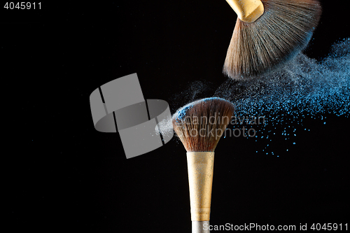 Image of Beautiful splash after touch of two professional brushes with powder particles on tip