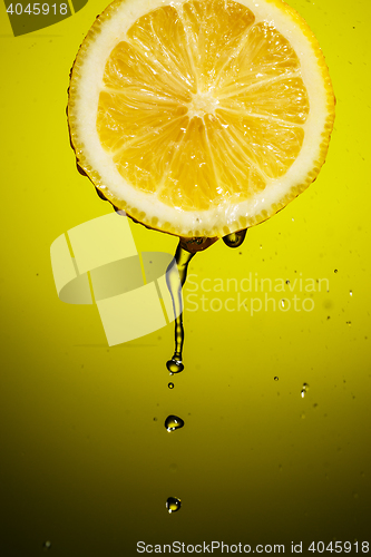 Image of Splash juice with lemon slice isolated on yellow background